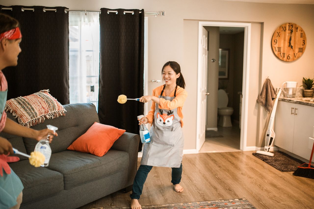 why-choose-us A cheerful couple engages in a playful cleaning session in their home.